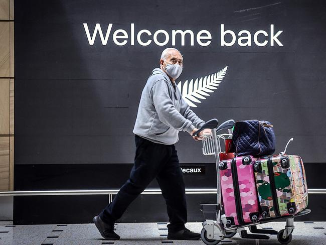 A passenger wearing a face mask arrives from New Zealand into Sydney when borders opened in October. NSW Health are tracking recent arrivals from Auckland. Picture: AFP