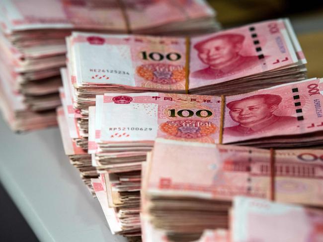 Bundles of 100 yuan (14.6 USD) notes are pictured at a bank in Shanghai on August 8, 2018. A rally in Asian markets stuttered on August 8, with early gains pared as the US-China trade row erodes investor confidence. But the yuan got some support after a news report said the Chinese central bank had emphasised the need for currency stability to the country's lenders as it looks to halt a slide in recent months. / AFP PHOTO / Johannes EISELE