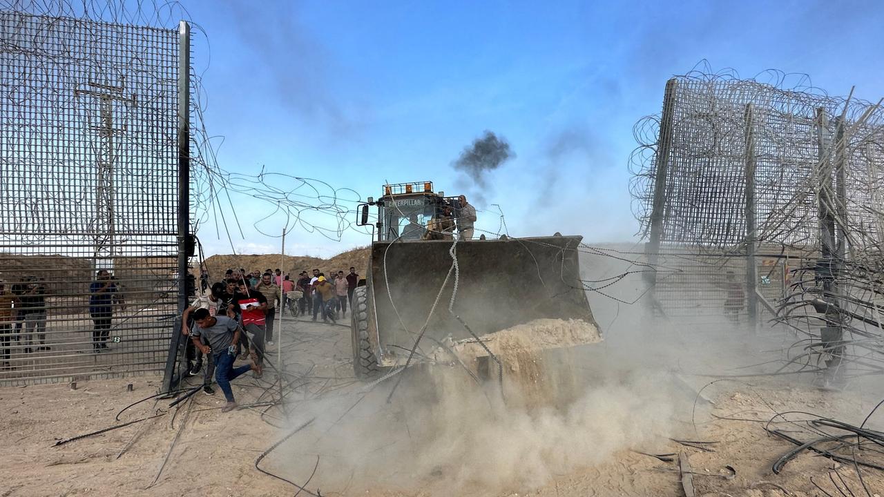 Palestinians breaking into the Israeli side of the Israel-Gaza border fence after gunmen infiltrated areas of southern Israel on October 7, 2023. Picture: Reuters/Mohammed Fayq Abu Mostafa