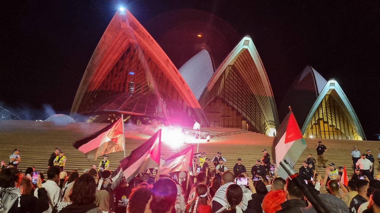 Protesters watched on as flares were thrown at police, who had barricaded the front of the Opera House. Picture: News.com.au / Jasmine Kazlauskas