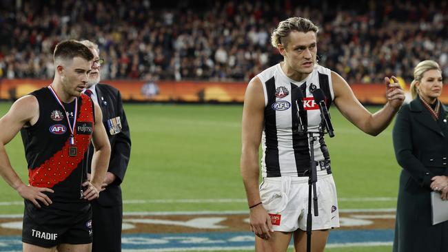 MELBOURNE , AUSTRALIA. April 25, 2024.  AFL.. Anzac Day.  Essendon vs Collingwood at the the MCG. Darcy Moore of the Magpies and Zach Merrett of the Bombers make a joint speech after the match was a draw    . Pic: Michael Klein