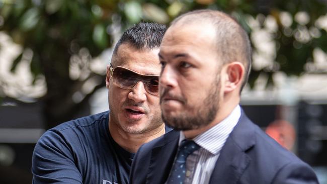 Accused drug trafficker Nedal Haouchar (left) tries to avoid being photographed outside Downing Centre Local Court in January. Picture: Julian Andrews