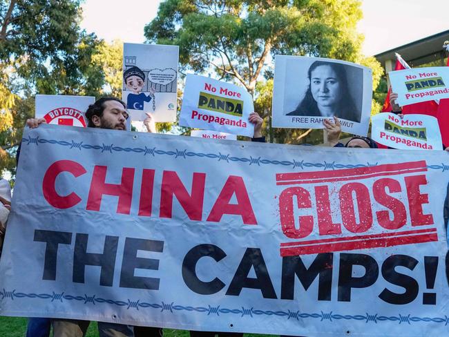 ADELAIDE, AUSTRALIA - NewsWire Photos - 16 JUNE, 2024:  Uyghur and counter-China demonstrators hold a banner and placards as they await the arrival of China's Premier Li Qiang at the Adelaide Zoo in Adelaide on June 16, 2024. Picture: NewsWire / Asanka Ratnayake / POOL