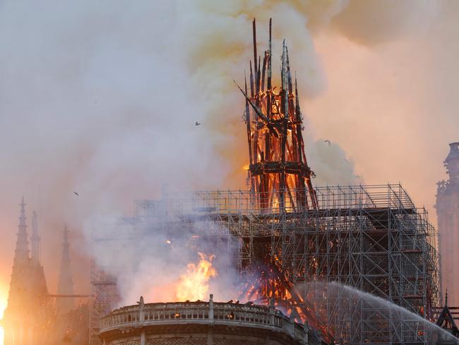 TOPSHOT - Smoke and flames rise during a fire at the landmark Notre-Dame Cathedral in central Paris on April 15, 2019, potentially involving renovation works being carried out at the site, the fire service said. - A major fire broke out at the landmark Notre-Dame Cathedral in central Paris sending flames and huge clouds of grey smoke billowing into the sky, the fire service said. The flames and smoke plumed from the spire and roof of the gothic cathedral, visited by millions of people a year, where renovations are currently underway. (Photo by FRANCOIS GUILLOT / AFP)