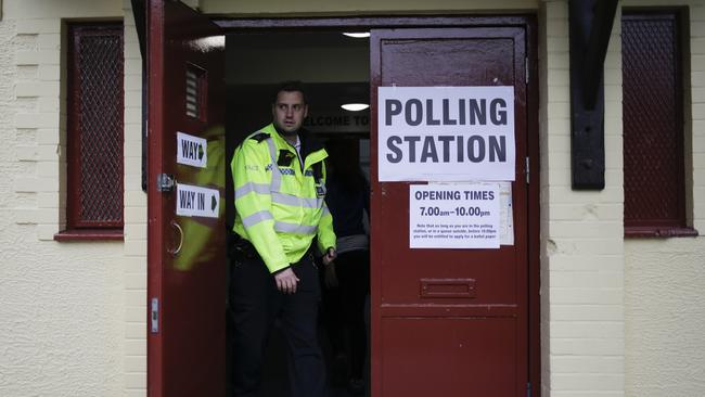 A police officer leaves the polling station for Britain's general election at Bermondsey Village Hall after he inspects the station in the London Bridge area of London. Picture: AP