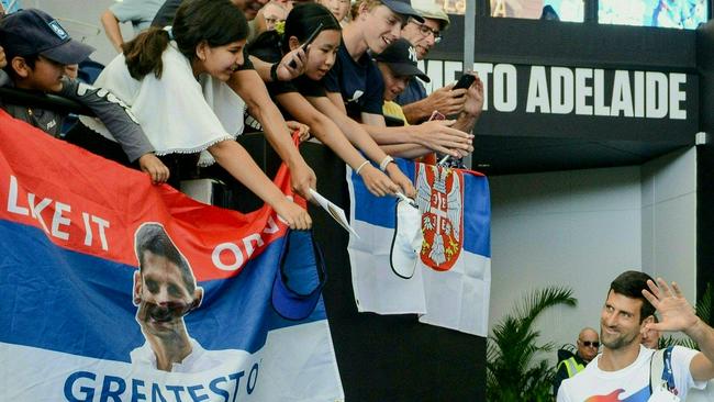 Novak Djokovic gestures to fans as he arrives for a practice session at Memorial Drive. Picture: AFP