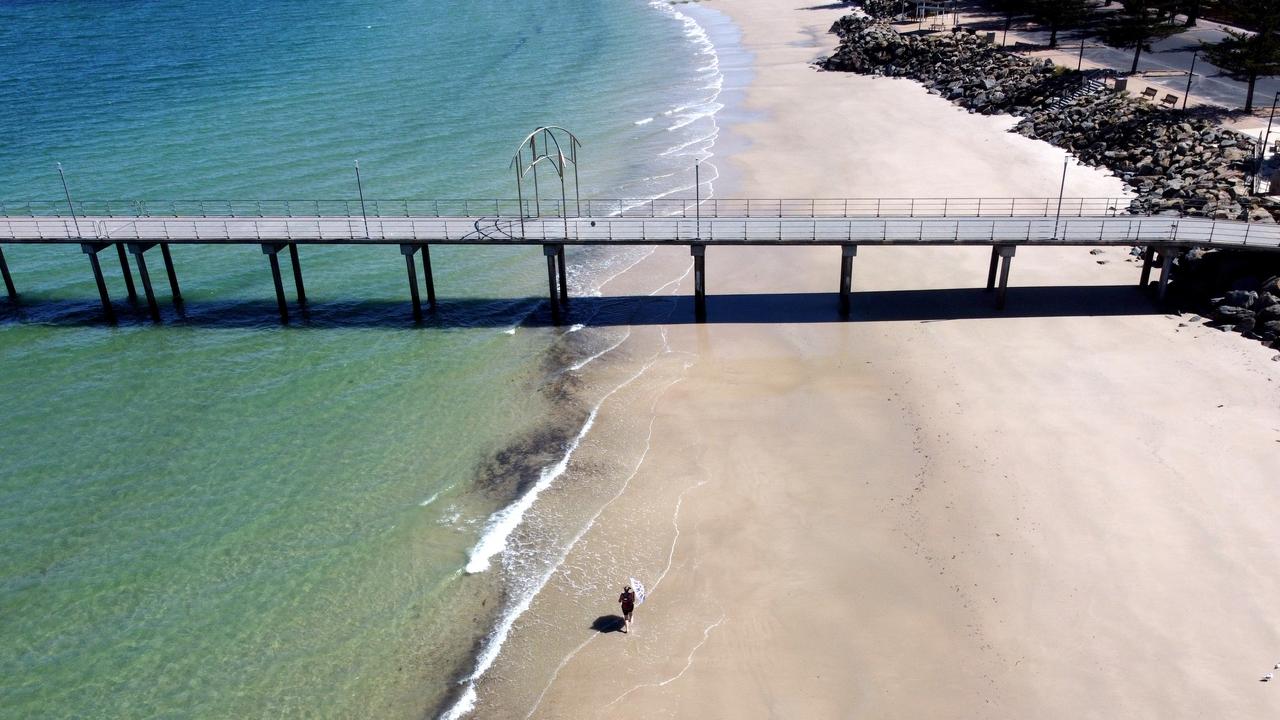 ADELAIDE, AUSTRALIA - NewsWire Photos November 19: A lone women walks along Brighton Beach on day 1 of the SouthAustralian 6 day Covid-19 Lockdown. Picture: NCA NewsWire / Kelly Barnes