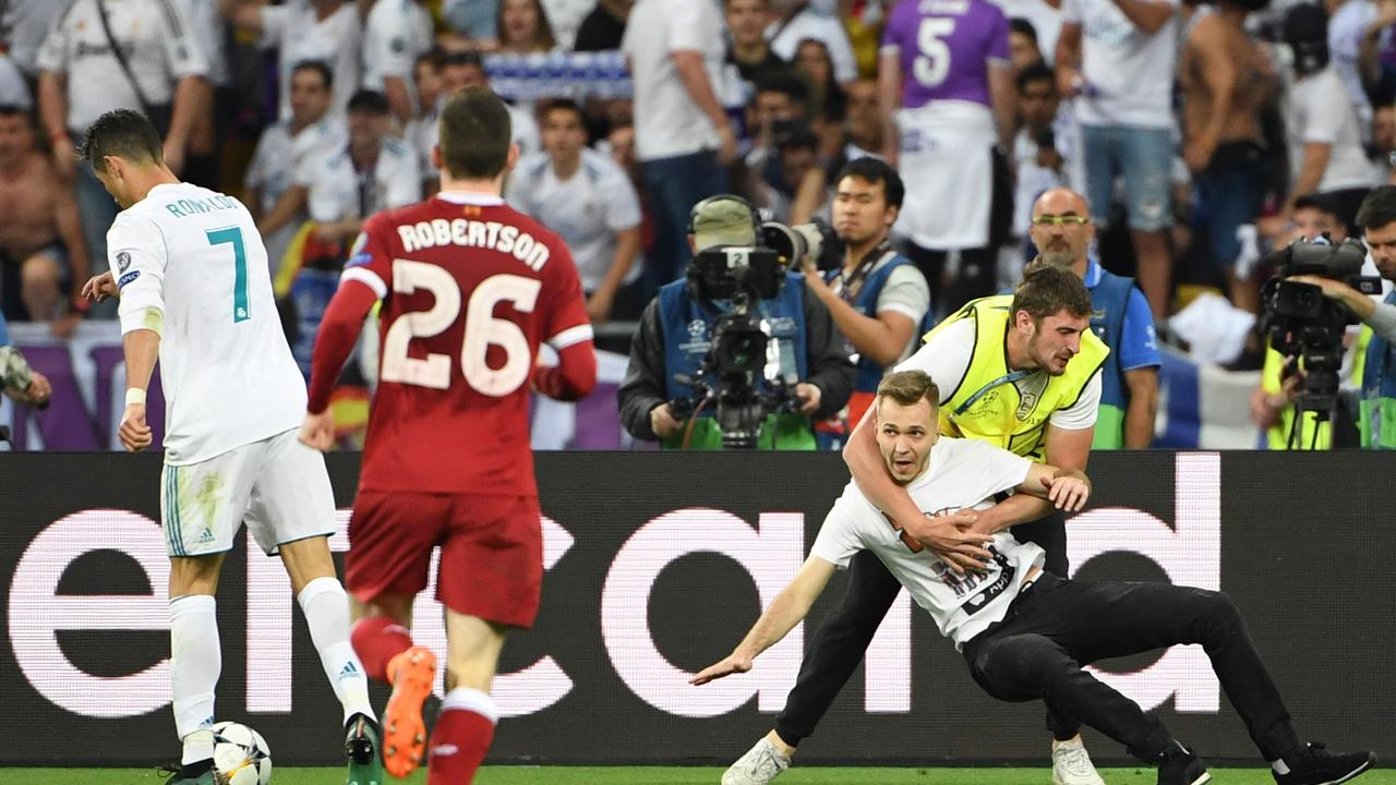 A pitch invader is tackled as Ronaldo (L) was closing in on goal during the UEFA Champions League final