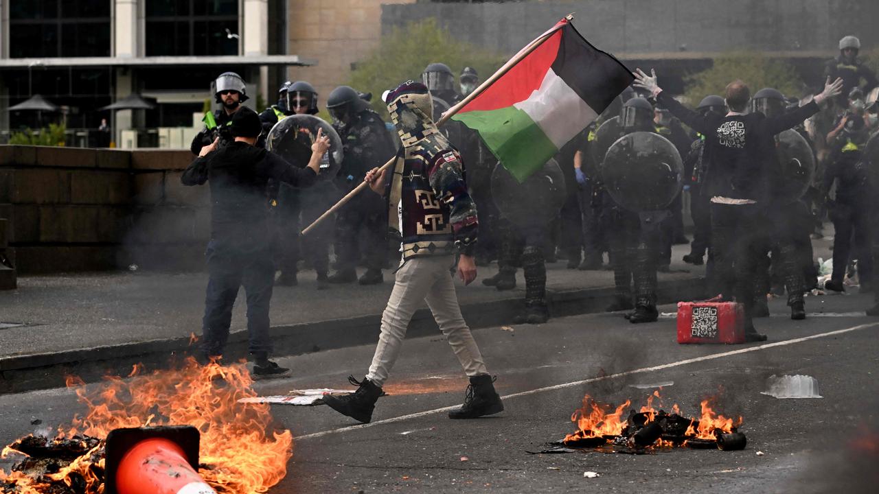 A man waves a Palestinian flag as protesters confront police. Picture: William West / AFP