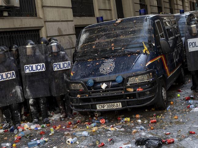 Spanish police stand outside a police station surrounded by objects thrown by pro-independence demonstrators in Barcelona. Picture: AP,