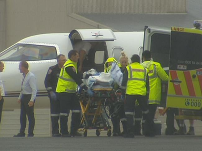 Paramedics exited the plane before it was backed into a hanger to unload the patient. Picture: Seven News