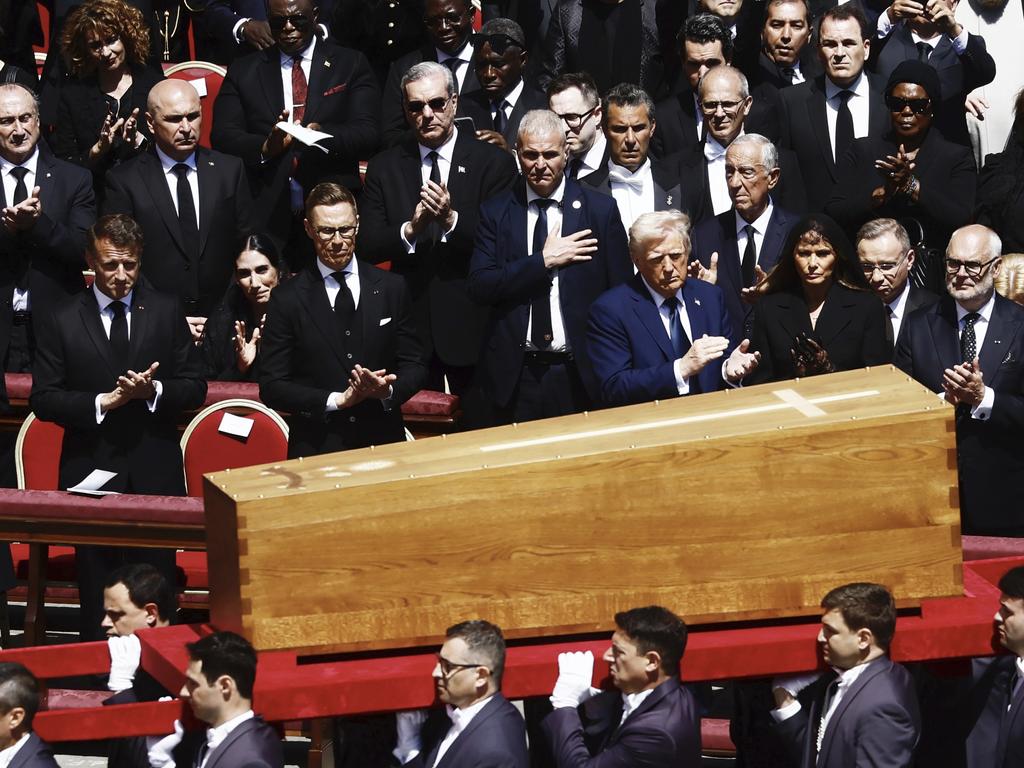 The coffin of Pope Francis is carried in front of dignitaries, including President Donald Trump, centre, and French President Emmanuel Macron. Picture: AP