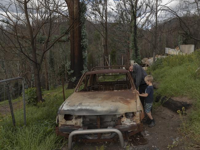 COBARGO, AUSTRALIA - MAY 09: Bushfire survivor Ian Livingston and his son Sydney, 6, are pictured amongst the ruins of their family home, lost to the New Years Day bushfires on May 09, 2020 in Cobargo, Australia. Ian stayed to defend his home but was quickly overrun by the firestorm. Ian took shelter behind a water tank, suffering severe burns. After walking up the road he was found by a police officer. The next thing he remembers is waking up in intensive care in Sydney, where he spent two weeks. Ian said I want people to know how grateful I am for the support since that day. Ian continues to rebuild his life, now living in nearby Bermagui, with no plans to rebuild at Cobargo. It was ten years of weekends to build the house, and I got to enjoy it finished for just a month before the fires he said. The small town of Cobargo on the New South Wales south coast was devastated when bushfires tore through the area on New Year's Eve on 31 December 2019. Two people were killed and dozens of homes and properties were destroyed as Cobargo became one of the worst affected communities by what is now known as the Black Summer fires. Just over four months on, recovery works are slowly beginning as contractors start to remove the rubble and remains of the destroyed buildings around town. For Cobargo residents, the road to emotional recovery has also been slow going as the current coronavirus (COVID-19) pandemic and social distancing measures further exacerbate feelings of isolation. (Photo by Brook Mitchell/Getty Images)