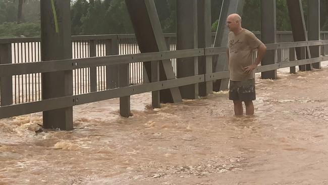 A man looks over the side of the Ballina Street Bridge during unprecedented flooding in South Lismore on February 28, 2022.