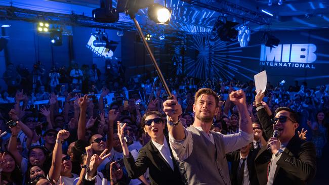 Chris Hemsworth has just put his hammer down before lifting a selfie stick to take a group shot with fans. Picture: Anthony Kwan/Getty Images