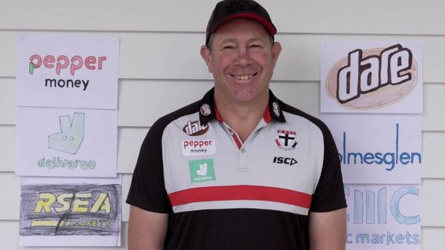 St Kilda coach Brett Ratten with the makeshift Saints sponsors signs crafted by his children. Picture: Twitter/StKFC