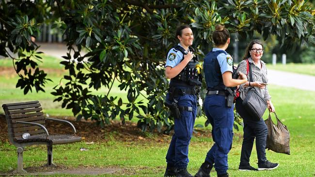 NSW Police officers ask a woman to move on at Rushcutters Bay today. Picture: AAP.