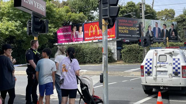 Bystanders talking to police following the shutdown of part of Maroondah Highway near Eastland due to a bomb threat. Picture: Kiel Egging.