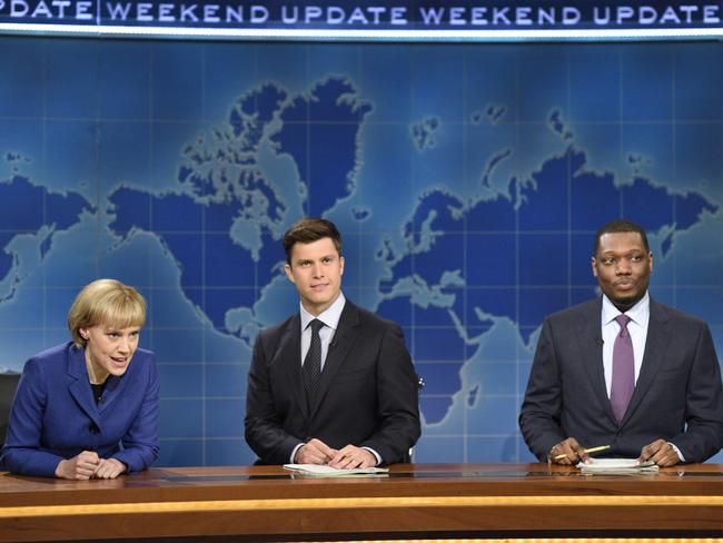 In this image released by NBC, Kate McKinnon portraying German Chancellor Angela Merkel, left, appears with Weekend Update hosts Colin Jost, center, and Michael Che during their segment on "Saturday Night Live," in New York on Sept. 30, 2017. (Will Heath/NBC via AP)