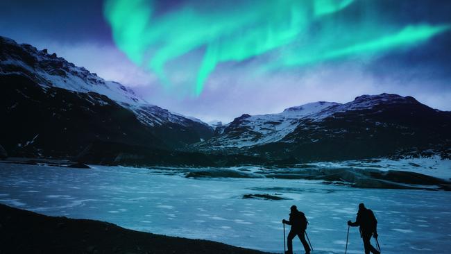 Hikers under the northern lights in Iceland