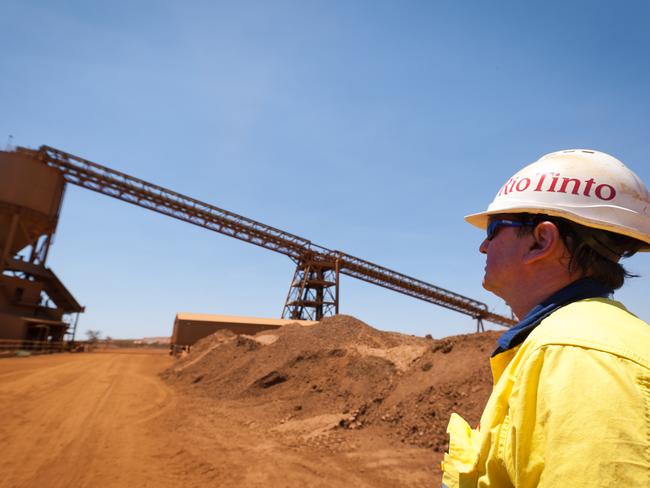 A mine worker looks at a train loader at Rio Tinto Group's West Angelas iron ore mine in Pilbara, Australia, on Sunday, Feb. 19, 2012. Rio Tinto Group, the world's second-biggest iron ore exporter, will spend $518 million on the first driverless long-distance trains to haul the commodity from its Western Australia mines to ports, boosting efficiency. Photographer: Ian Waldie/Bloomberg