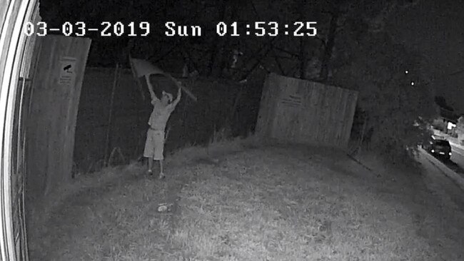 A man tosses an election poster over a fence in Carlingford.