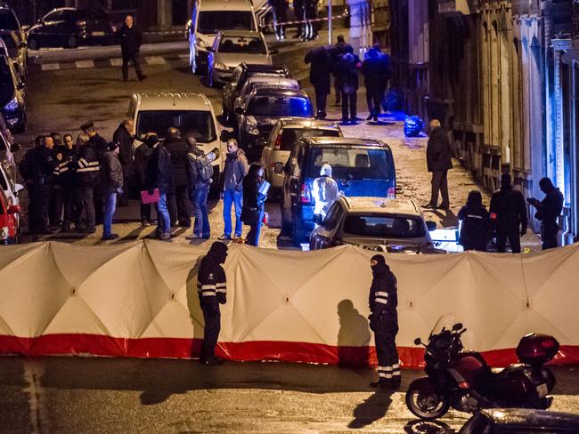 Belgian police officers gather behind a screen as they investigate a a shootout in an anti-terrorist raid in a street in Verviers, Belgium. Picture: AP Photo/Geert Vanden Wijngaert