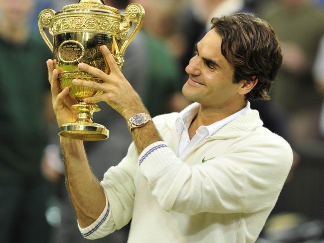 08/07/2012 WIRE: Switzerland's Roger Federer celebrates with the trophy after his men's singles final victory over Britain's Andy Murray on day 13 of the 2012 Wimbledon Championships tennis tournament at the All England Tennis Club in Wimbledon, southwest London, on July 8, 2012. Federer won the match 4-6, 7-5, 6-3, 6-4. AFP PHOTO/ GLYN KIRK RESTRICTED TO EDITORIAL USE Pic. Afp