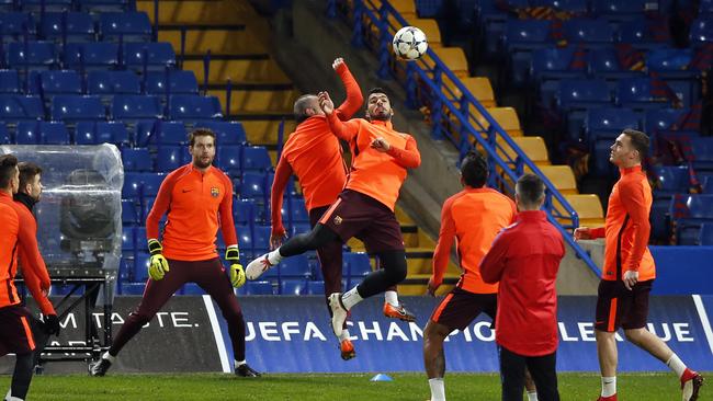 Barcelona's Luis Suarez, center right, jumps for a ball with Andres Iniesta during a training session at Stamford Bridge