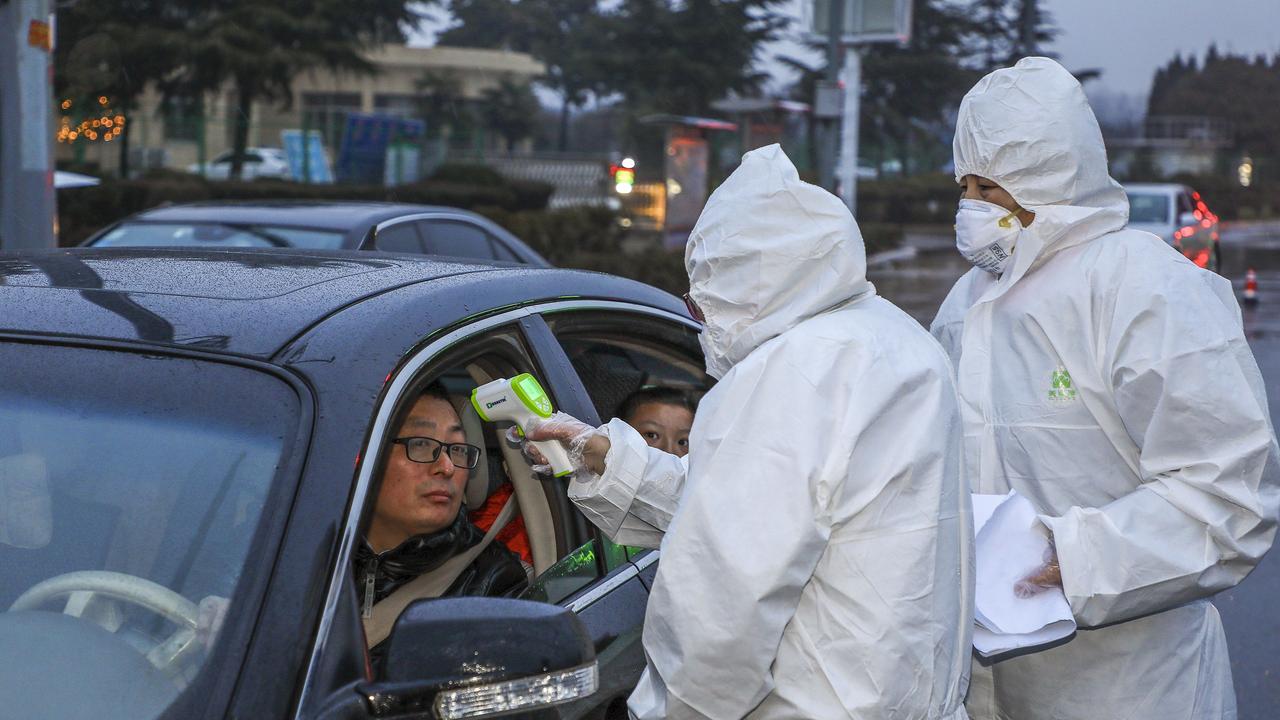 A driver has his temperature checked by medical staff in Tengzhou, China. Picture: AFP/STR