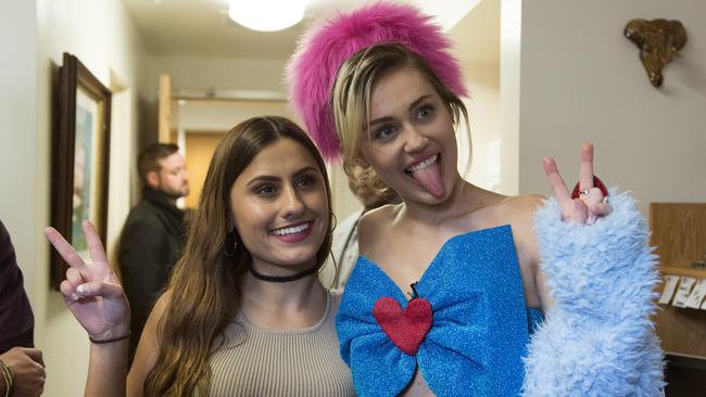 Cyrus pulling her usual face as she poses with a fan.