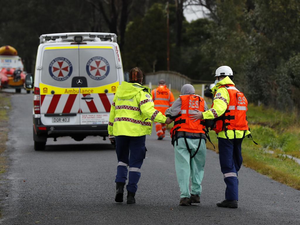 Paramedic assist an elderly lady is evacuated from Ellis Lane near Camden. Picture: Jonathan Ng