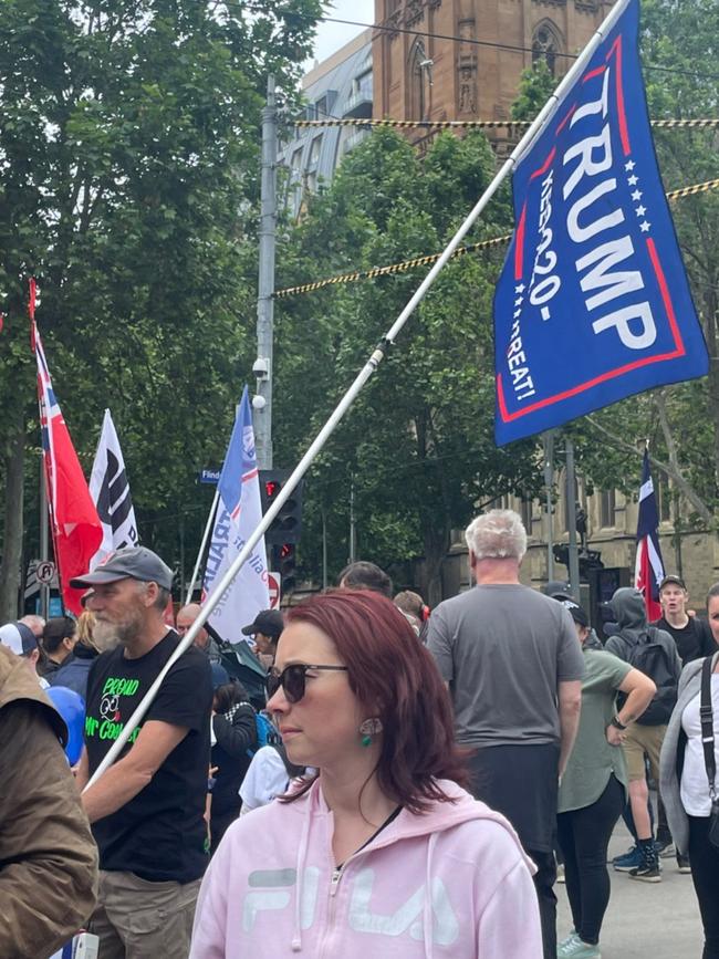 A protester carrying a Trump 2020 flag.