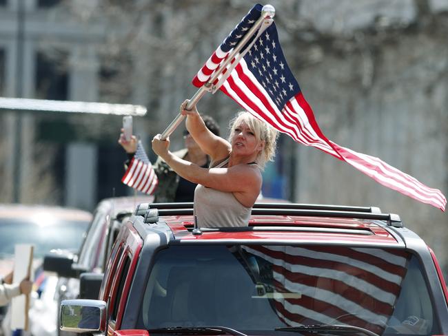 A protester waves an American flag during a car protest against the stay-at-home order issued by Colorado Governor Jared Polis. Picture: AP