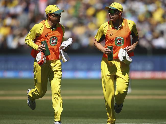 MELBOURNE, AUSTRALIA - FEBRUARY 14: Michael Clarke of Australia and James Faulkner of Australia run drinks during the 2015 ICC Cricket World Cup match between England and Australia at Melbourne Cricket Ground on February 14, 2015 in Melbourne, Australia. (Photo by Ryan Pierse/Getty Images)