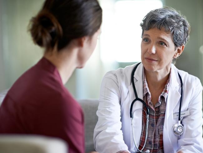 Shot of a compassionate doctor comforting a young woman in a hospital waiting room; fear health scare generic