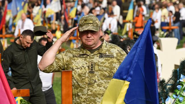 An officer salutes at a ceremony for the fallen soldiers of Ukraine. The country seems to have come to a grim acceptance that national freedom is worth almost any price. Picture: AFP