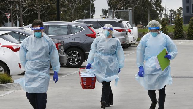 Staff arrive in protective clothing. Picture: David Caird