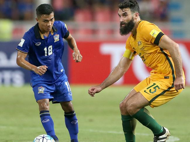 Mile Jedinek (right) and Chanathip Songkrasin. The Socceroos Vs Thailand at Rajamangala Stadium in Bangkok. Pic Jono Searle.