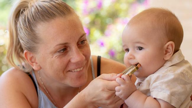 Shelley Watts introduces son Chase to her 2014 Commonwealth Games gold medal at home in Port Macquarie. Picture: Lindsay Moller