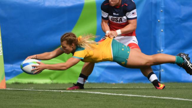 Australia's Emma Tonegato scores a try as she is tackled by USA's Alev Kelter in their last pool match.