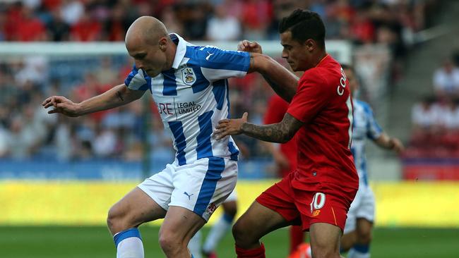 Aaron Mooy (L) of Huddersfield Town challenged by Philippe Coutinho of Liverpool.