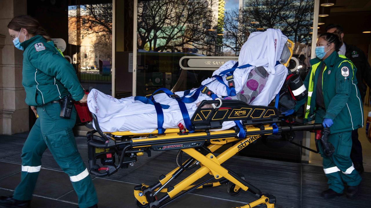 With a sheet covering her face and body, Raelene Polymiadis is wheeled out of the Adelaide Supreme Court by ambulance officers after collapsing in the court cells. Picture: NCA NewsWIRE / Emma Brasier