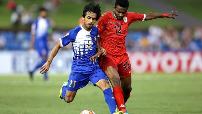 Ali Al-Maqseed of Kuwait contests the ball against Ahmed Mubarik of Oman.