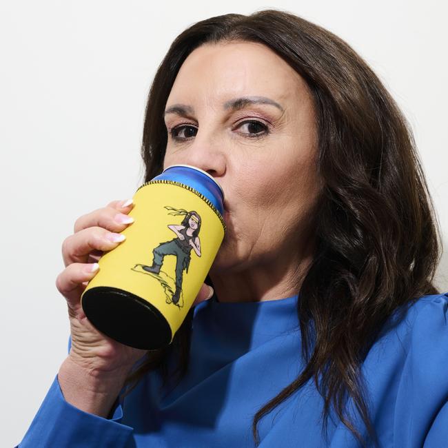 Lambie sips from a stubby holder featuring illustrated characters “Jacqui Rambo”. Picture: Rohan Thomson