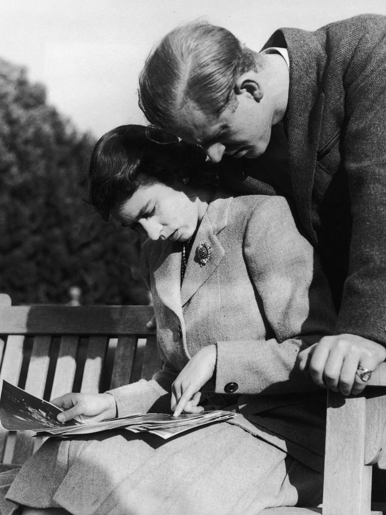 Princess Elizabeth (now Queen Elizabeth II) and her husband, Philip Mountbatten, study their wedding photographs while on honeymoon in Romsey, Hampshire, November 1947. (Photo by Keystone/Hulton Archive/Getty Images)