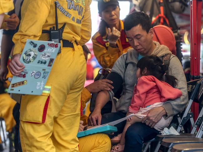 A man carrying a child receives medical attention at a temporary rescue command post after being rescued from the Taroko National Park in Hualien. Picture: AFP