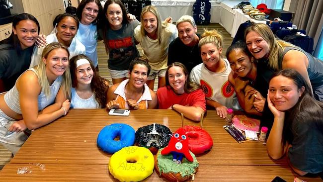 Australia's women's rugby team and their unique team bonding moments ahead of the Paris Olympics. Team members with the Olympic ring cakes they designed.