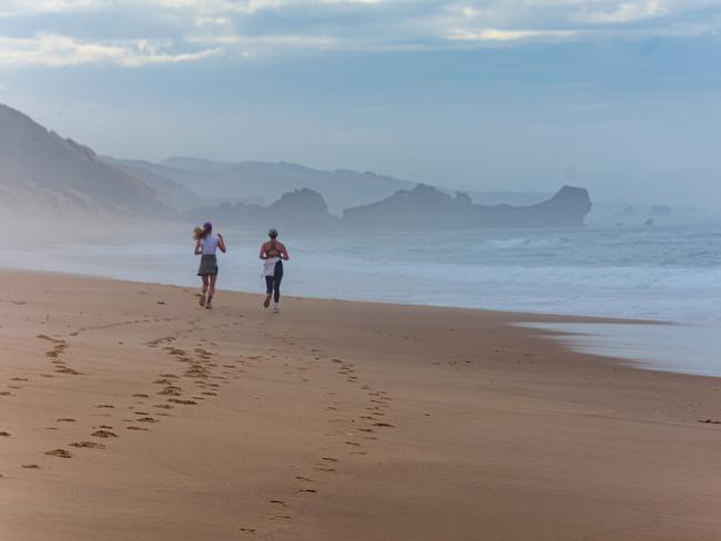 Young women enjoying a morning jog towards Elephant Rock on a hazy Portsea Back Beach. Picture: Geoff Chatfield, Frankston South.