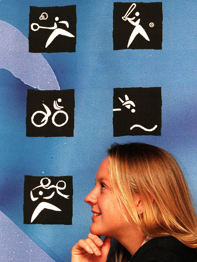 Swimmer Stacey Gartrell stands in front of the Paul Saunders-designed pictograms used during Sydney 2000 Olympic Games.